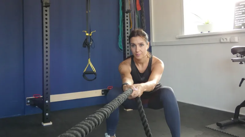 Vrouw traint met battle ropes in de zaal van Convert2Fit
